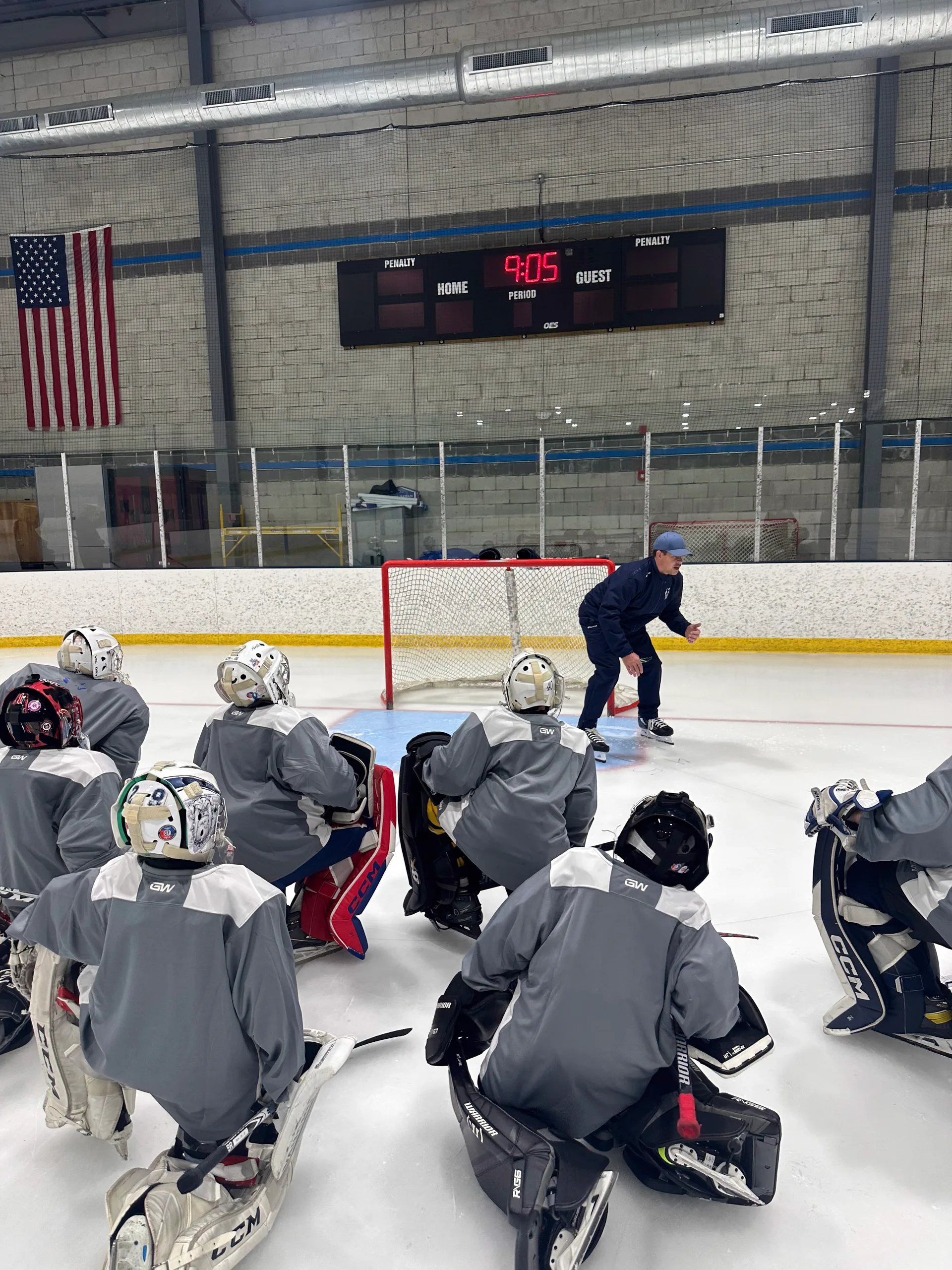 Coach addressing a group of goalies on the ice