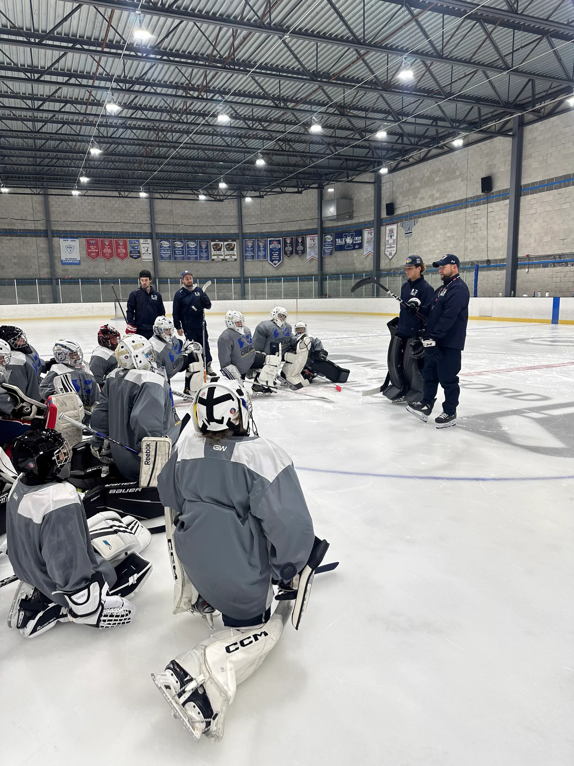 Connecticut Crease coach working with a goalie on the ice